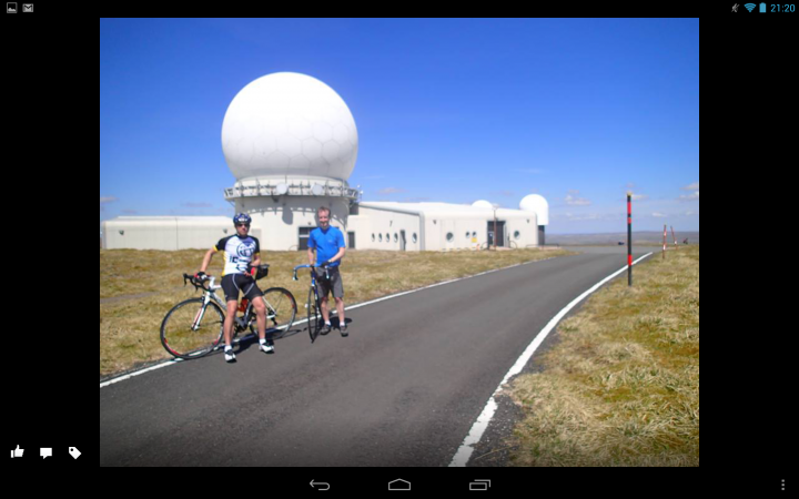 A group of people riding bikes down a street - Pistonheads - The image captures a moment of exploration near a prominent landmark, specifically a large satellite dish. In the foreground, two individuals on bicycles are pose for a photo, their attention drawn to the site behind them. They are wearing casual attire appropriate for a bike ride, indicating a leisurely ride rather than a workout. The satellite dish, which is the main subject of the photograph, looms large in the background, its massive size and reflective surface emphasizing the scale and power of modern technology. The concrete path they are on suggests a well-maintained pathway, possibly even a designated bike route. Overall, the image conveys a sense of adventure and curiosity, as these two cyclists explore this interesting site.