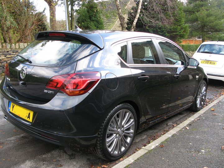 Pistonheads - The image showcases a black Peugeot hatchback car parked on a street located near a stone wall. The vehicle is parked adjacent to a yellow letter 'A' plate, which suggests it might be in a country where vehicles display the initial of a French phrase.