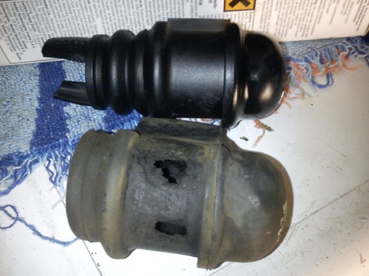 A close up of a fire hydrant on a city street - Pistonheads - The image shows two mechanical parts that appear to be black and dirty, likely due to use or exposure to elements. They seem to be a type of connector or component from a vehicle, given the visible B102 slot which is a common type found on V-8 engines. The parts are laid out on a surface covered by a blue object, which might be a cloth or mat. There is also a faded instructional label visible in the background, accompanied by a yellow symbol that might be a cautionary sign. The overall setting suggests this image was taken during a repair, maintenance, or troubleshooting process.