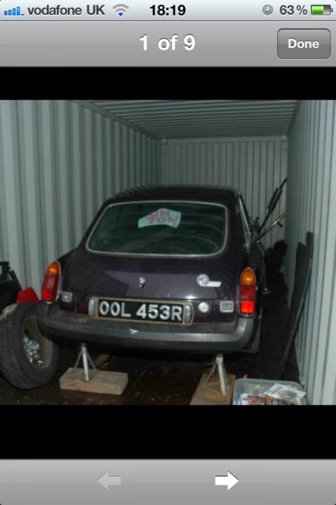 MGB GT 2.0 Duratec Sebring - Page 1 - MG - PistonHeads - In the image, a dark car is prominently featured, occupying a significant portion of the scene. It's positioned inside a shipping container, adjacent to a mechanical fork, suggesting it may have been loaded for transport. Above the car, a slice of pink cake is affixed to the carrier's window, possibly used to hold it in place. The car, the slice of cake, and the mechanical fork all contribute to a scene of preparation for shipment.