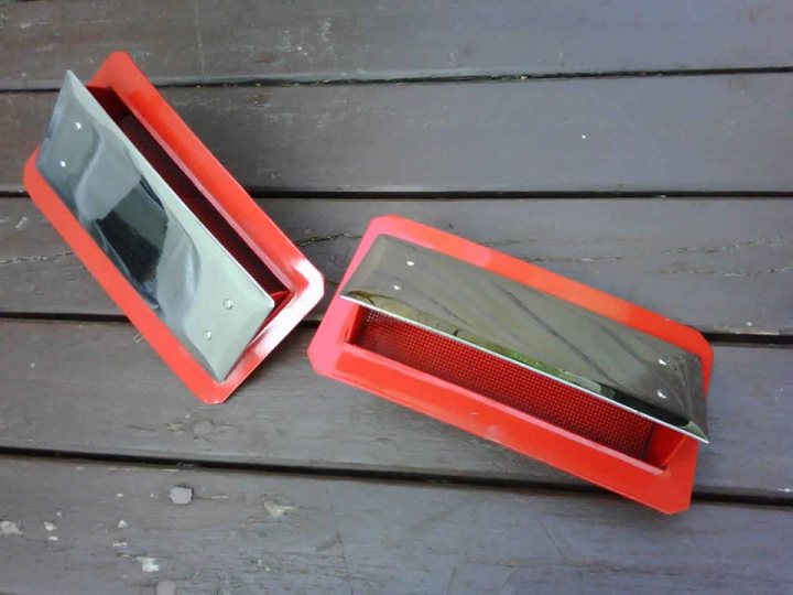 Tvr Griffith side louvre door - Page 1 - Classics - PistonHeads - The image shows two red plastic weapon cases on a wooden surface. These cases are commonly used to store bladed weapons like knives. Each case is fitted with a silver metal blade protector that slides in and out to prevent the sharp edges from being in contact with the plastic. The interior of the cases appears to be a darker shade, possibly to protect the edges of the blades. The surface of the protective cases is smooth, with a slight texture that might be intended to prevent slippage when the blade is in use or when sliding in an out of the case.