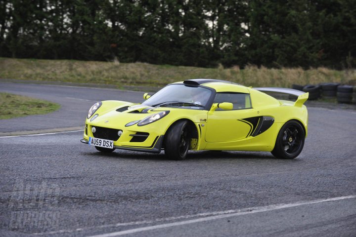 Pistonheads - The image shows a vibrant yellow Mazda RX-7 taking a tight turn on a street. The car is a red, white, and blue racing vehicle, suggesting it's been modified for high-performance driving, possibly even being used in a racing event. The vehicle is captured in motion, defying gravity as it clings to the edge of the road while navigating the turn. The backdrop of the image is an urban setting with trees and buildings, indicating the car is on a city street. The overall atmosphere is one of excitement and speed.