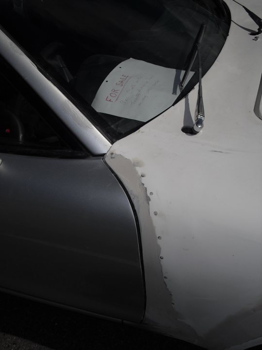 A close up of a car with a mirror - Pistonheads - The image shows a white car interior, featuring a piece of paper with "Forsale" written on it on the dashboard. The car appears used with some wear, including scratches and specks on the plastic dash. A leverage trochanter (LT) is visible in the foreground of the photo. The "Forsale" sign indicates someone is selling this car.