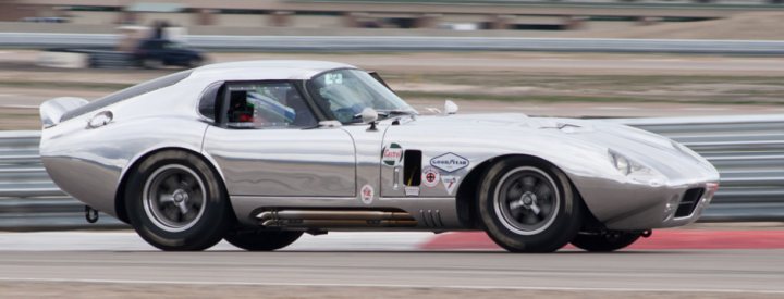 A car is parked on the side of the road - Pistonheads - The image captures a dynamic scene on a race track. Dominating the frame is a silver sports car, its sleek design and shiny surface reflecting the light. The car is in motion, with one back tire slightly lifted off the ground as it approaches a turn. The background is a blur of other cars, suggesting a high-speed chase or race.