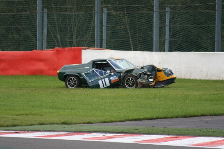 A motorcycle parked on the side of a road - Pistonheads - The image shows a scene of a car accident on a racetrack. The car, positioned in the center and facing left, has collided with a tall, gray metal guard rail. It appears to be in a state of disrepair, suggesting a violent impact and subsequent crash. The crushed metal of the car's bodywork is visible, with parts of the vehicle scattered all over the track. In the background, there is a red safety barrier and a white wall, indicating typical elements of a racetrack trackside area. The image conveys the force of impact during the incident.