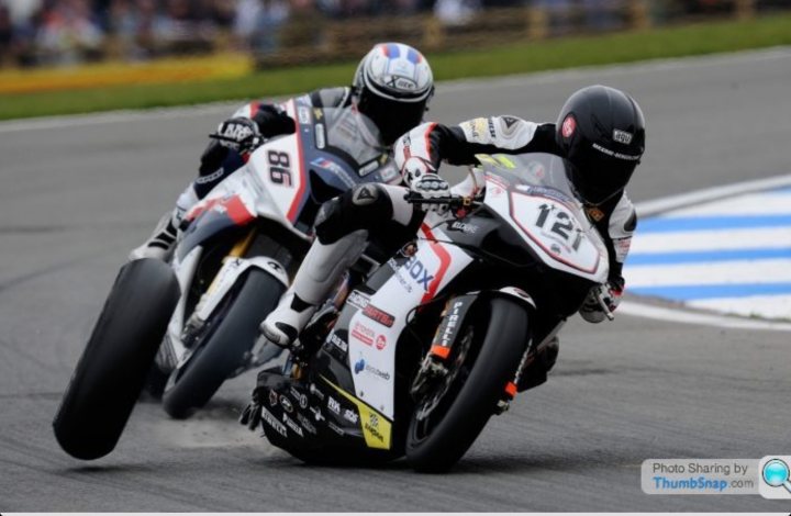 Just awesome vehicle-related images. - Page 6 - General Gassing - PistonHeads - The image captures an intense moment during a motorcycle racing event. Two professional bikers, clad in protective gear, are leaning into a curve, their motorcycles leaning right towards the camera. The riders are in full racing gear with helmets, which suggests a hardcore racing scene with a level of risk involved. The dynamic angle of the shot emphasizes the speed and skill of the riders. The motorcycles appear to be specially designed for racing, with visible sponsorship logos, like B-X, indicating the competitiveness of the event.