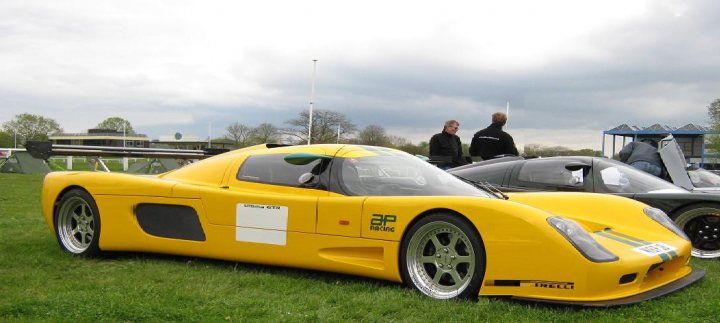 Extend your car... - Page 2 - General Gassing - PistonHeads - The image displays a vibrant and field of green grass. A classic yellow Corvette sports car is the centerpiece of the scene, with its vivid color contrasting with the natural hues of the grass. The car is parked and facing the camera, giving a clear view of its iconic design.

Behind the Corvette, there are two individuals who appear to be inspecting the vehicle, possibly mechanics or enthusiasts. They are standing at a safe distance and are dressed in casual clothing suitable for outdoor activities.

The environment is open and spacious, and there are a few trees in the distance, indicating that the setting might be a park or a similar public space. There are no other vehicles or significant landmarks visible in the image, and the focus is primarily on the sports car and its potential admirers. The overall ambiance of the image is one of leisure and appreciation for classic automobiles.