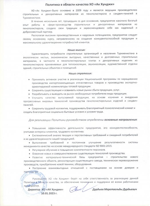 The image is a photograph of a printed document, which appears to be a notice or announcement written in Cyrillic script. It includes several sections with headings and lists of text, although the content of the document is not clear from the image. The layout suggests an official communication, possibly related to a formal event or decision, given the structured format and the inclusion of a signature. The document is set against a background that is out of focus, making it difficult to discern any specific details about the location or setting where the photo was taken.