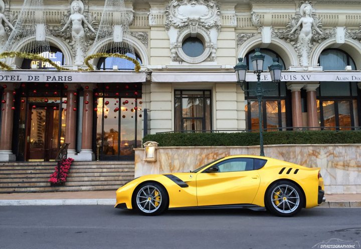 the most beautiful modern car today - Page 2 - General Gassing - PistonHeads - The image portrays a stylish scene on a street where a yellow sports car is parked in front of a luxurious building. The building is adorned with classical architecture, featuring a large facade with a European-style design, complete with ornate columns and elegant windows. The street itself is neat, with a well-maintained sidewalk that houses a sign indicating the Hotel De Paris. The overall atmosphere suggests a well-kept and upscale urban environment.