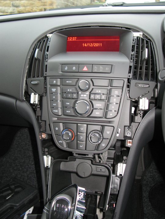 Pistonheads - The image showcases the interior of a modern car, focusing on the center console. The dashboard prominently displays the date and time, indicating it's December 14th, 2011. The vehicle is equipped with a digital radio display and several buttons and dials, typical of a car's control panel. The gear shift, a key component of a manual transmission car, is visible, suggesting the car is not an automatic model. The overall atmosphere of the image suggests a state of preparedness, possibly for a journey or of a recently started vacation trip.