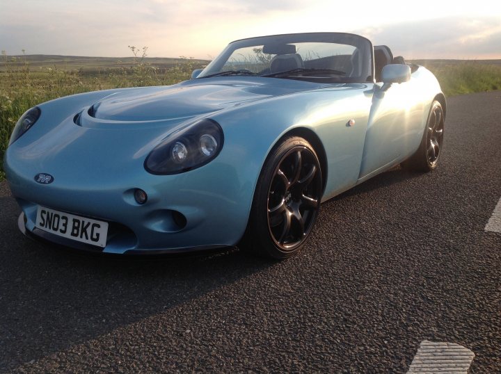 Show us ya cars... What you blasting around in 2015? - Page 12 - Yorkshire - PistonHeads - The image showcases a vibrant blue Ford Mustang GT Convertible driving on a road during the day. The car's top-down design allows for a panoramic view of the clear blue sky. In the background, a scenic field stretches across the landscape, indicating the car might be in a rural or suburban setting. It's daytime, as suggested by the bright lighting and the open layout of the road.