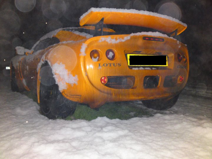 Pistonheads Supercars Dirty - The image depicts a striking scene of a stationary car, heavily white with patches of black, encased in a thick layer of snow. The car's body, spared at the bottom, contrasts with the vibrant yellow Loti roof. The snow-covered vehicle is parked facing the side, with the wind stark and illuminated, suggesting the power and swiftness of nature in a winter chill. The overall atmosphere speaks of resilience, as life endures amidst harsh weather conditions.