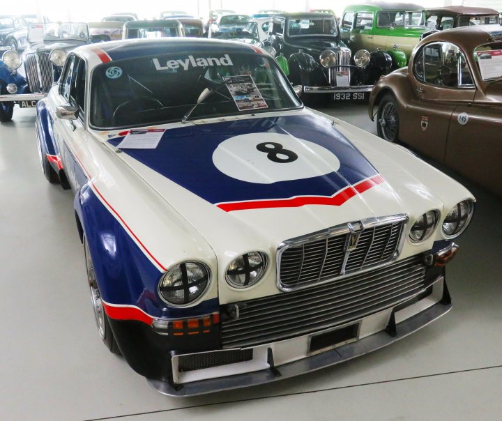 Pistonheads - The image showcases a classic car, specifically a Leyland Formula 1 race car, parked indoors in what appears to be a showroom or museum dedicated to antique cars. The car is predominantly white and blue, with the number 8 prominently displayed on its side. It features a distinctive red stripe running along the hood. The setting suggests an event where classic and vintage vehicles are exhibited and admired by enthusiasts and visitors alike.