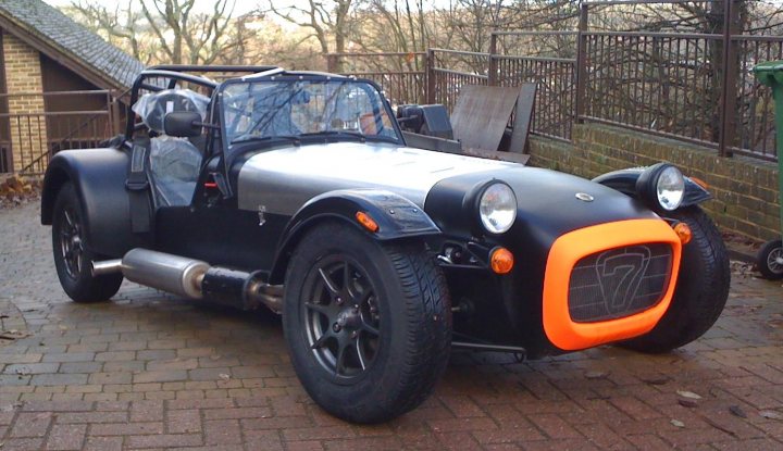 Pistonheads - The image showcases a black and orange sports car parked outside, likely on a brick pavement. The car has a distinctive style, suggesting it's a custom or old model. It's a convertible, indicating the driver can enjoy the elements like they did in the early years of convertible automobiles. The overall condition of the car looks fairly well-maintained, despite the outdoor setting.