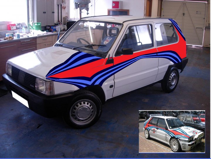 Pistonheads - This image depicts a small white car parked inside a garage or workshop environment. The car is restyled with a unique and striking stripe design in bold red and blue hues that contrast sharply with its original white color. The striping patterns appear to be abstract and are a mix of stripes and swirls. The car is positioned centrally in the image, with its front facing the viewer. The setting includes a workshop bench to the left and some equipment and items scattered throughout the background.