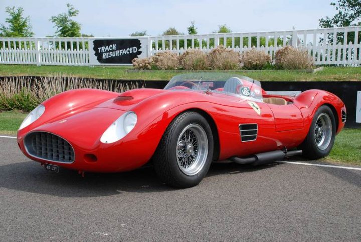 Pistonheads Sunday Supercar - This image features a striking red sports car positioned against a white picket fence. The car, with its sleek design, prominently displays the word "track" across its body, hinting at its purpose for high-speed racing or testing. It is parked on a road that appears to be used for such activities, surrounded by greenery that contrasts nicely with the car's vibrant color. The image exudes a sense of speed and power, associated with the world of motorsports.