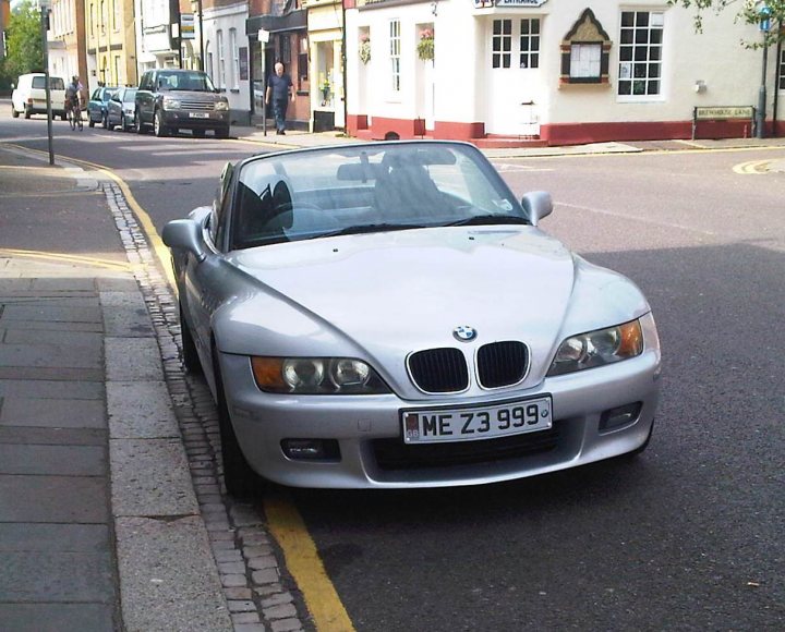 Pistonheads - The image shows a silver BMW car parked on the side of a street. The car is sleek and modern with distinctive BMW design. The vehicle has a license plate that reads "ME Z3 999." The setting appears to be in a neighborhood or town, with buildings lining the street, and the surface of the ground appears to be asphalt, likely a typical urban road. The image captures the car from a side angle, emphasizing its sporty design.