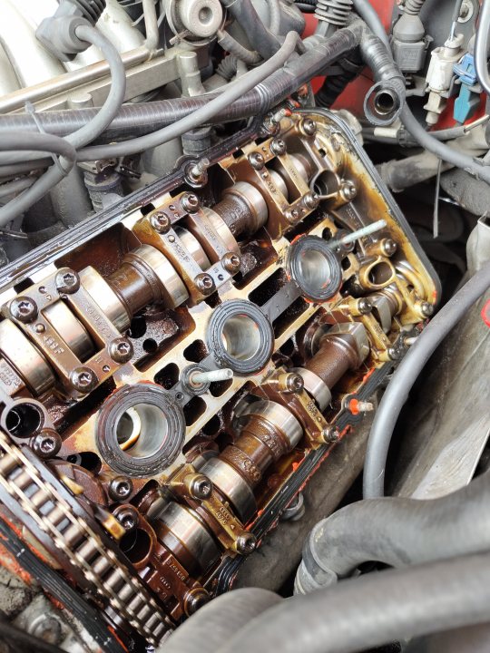 Pistonheads - The image captures a scene from an automotive shop, focusing on a used car engine. The engine is disassembled and rests on the ground, revealing its internal components which appear worn. A collection of tools are scattered around the engine, indicating recent or ongoing work. The overall atmosphere suggests a workspace dedicated to mechanical repairs and maintenance.