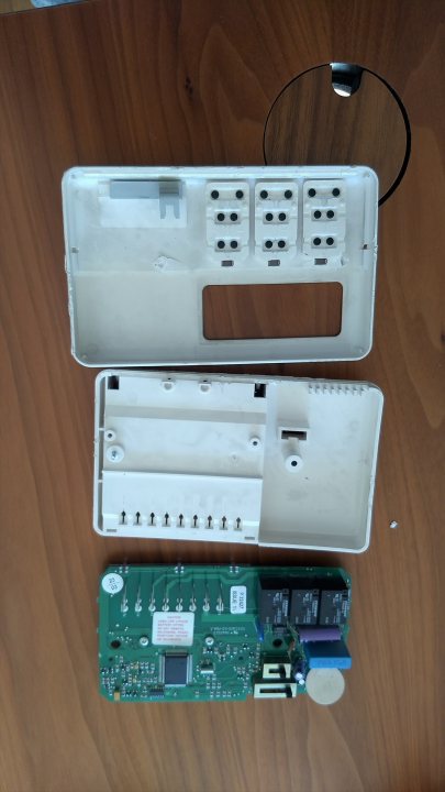 Horstmann heating timer - how to remove? - Page 2 - Homes, Gardens and DIY - PistonHeads - The image presents a scene of disassembled technology. An opened laptop, showing its internal components and wiring, is placed on the left side of the frame. On the right, there's an open box for what appears to be a Nintendo Wii console, with its controller and sensor bar lying next to it. The overall setting suggests a workspace or repair area.