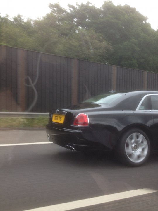 SAS Spotted Vol 2 - Page 178 - Thames Valley & Surrey - PistonHeads - The image shows a scene from the inside of a vehicle, specifically the rear window, with the driver on the left. There is a car in the middle lane of a highway, and the interior of the car shows a registration plate that reads "M40 YV7." The highway is flanked by wooden fences and grass, leading to trees in the distance. The sky appears to be overcast with clouds.