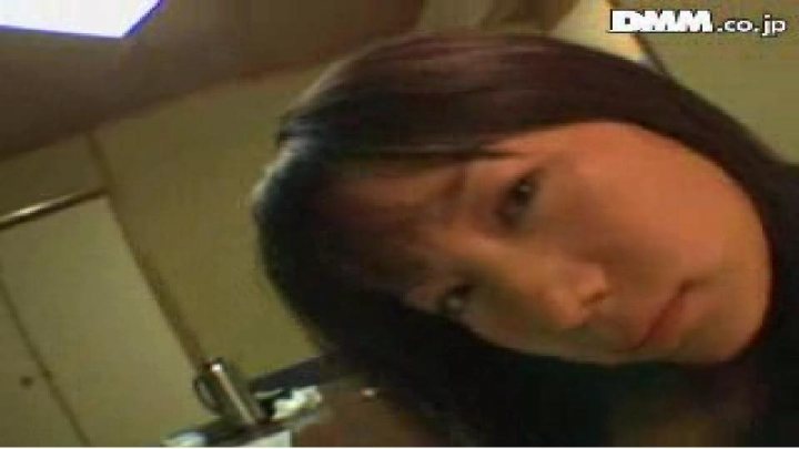 The image shows a close-up of the lower part of a person's face, presenting a profile view. The person appears to have dark hair on the forehead and half of the face is visible. Their expression is neutral, and the background is out of focus, with indistinct shapes suggesting an indoor setting. The text "DMM ??????" which is Chinese for "Good morning", is superimposed on the image, indicating it might be a screenshot from a video, possibly from a gaming or streaming platform.