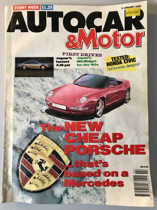 A car parked on the side of a road next to a stop sign - The image is of the cover of an October, 1990 issue of "Automobile & Motor" magazine. It is a Caucasian male, roughly between 18 to 24 years old, shown smiling, wearing a dark tee shirt with white text. In the background, there is a bookcase with a variety of books. A woman is standing in front of a factory, holding a clipboard and observing a man working.