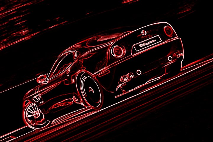 Gran Turismo 6 picture thread - Page 5 - Video Games - PistonHeads - The image showcases a striking red Ferrari, caught in a motion blur effect that suggests it's moving at high speed. The blurred lights in the background give a sense of motion and perhaps the late evening or early morning conditions, adding a dramatic and dynamic element to the scene. The Ferrari itself is a famous sports car, known for its sleek design and powerful engines, symbolizing luxury, performance, and exhilaration. The overall composition of the image, with the car in the foreground and the background engulfed in a red hue, creates a visually striking contrast that emphasizes the speed and presence of the vehicle.