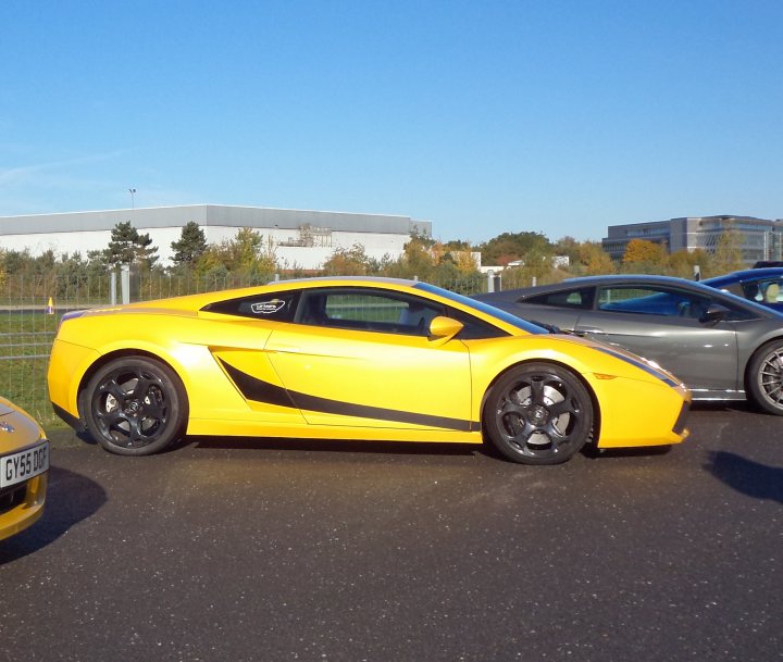 A red car is parked in a parking lot - Pistonheads