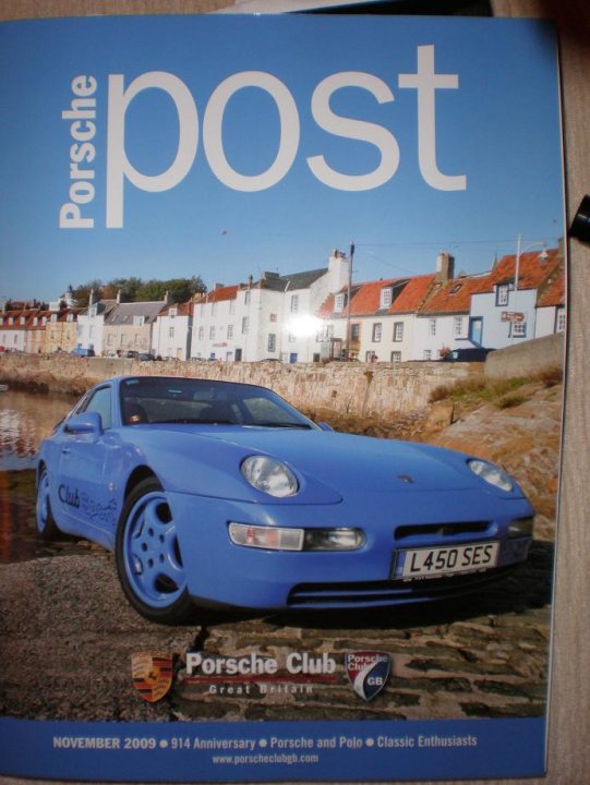 Warning Pistonheads Frontrunner Loves - This image presents a striking display of a blue Porsche Club sports car, which is prominently featured on the cover of a magazine titled "Porsche Post". The car, with its vibrant blue color and sleek black and white license plate, is parked on a cobblestone street. The backdrop is equally charming, featuring a row of quaint white buildings with red roofs. Above, the sky is a serene blue, adding to the picturesque view. Notably, the text on the cover reveals that this is a special edition that commemorates the magazine's 40th anniversary as well as Porsche and Pointe's classic enthusiasm.