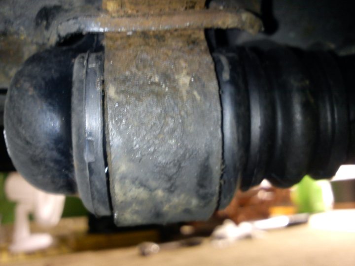 An old rusted fire hydrant sitting on a sidewalk - Pistonheads - The image is a close-up photograph taken in artificial lighting, likely from someone's perspective looking up at mechanical or automotive components. In the focused area of the image, there is rusted metal with a circular profile and a partial open clamp with worn edges. The metal appears aged with signs of use and corrosion. Above the rusted metal, a section of what could be a vehicle suspension or exhaust system is partially visible, suggesting a mechanical or industrial context.