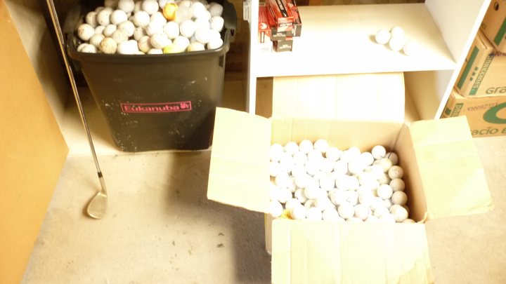 A table topped with a bowl of cereal and a banana - Pistonheads - This image captures a unique and interesting scene. A black garbage can is filled to the brim with golf balls, creating an unusual and intriguing sight. Adjacent to the garbage can, an opened, cardboard box rests on the same carpeted floor. The lid of the box is removed, revealing its contents which is more golf balls, further emphasizing the golf ball motif. On the right side of the photo, there is a window with white blinds partially open, allowing a small amount of natural light to filter into the room. In the background, there are several boxes stacked neatly, suggesting an organized storage space. The precise arrangement of these objects and their contrasting colors makes this image quite captivating.