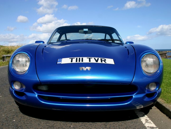 A blue car with a surfboard on top of it - Pistonheads - The image captures a vibrant blue sports car positioned in the foreground against a backdrop of clear blue sky with scattered clouds. The car's sleek design is accentuated by the attention to detail in the license plate that reads "TI LTV." The scene conveys a sense of anticipation and adventure, inviting the viewer to imagine the thrilling journey that lies ahead.