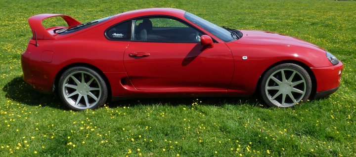 A red car with a surfboard on top of it - Pistonheads