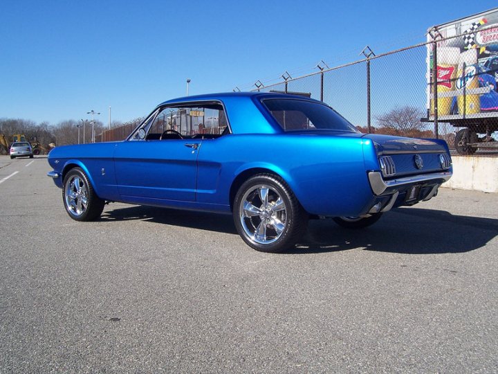 New owner what do you guys think. - Page 1 - Mustangs - PistonHeads - The image depicts a bright blue vintage Mustang car parked on a clear day. The car, a 1965 classic muscle car, is distinguished by its dark-colored wheel rims and black roof. It's parked on a concrete surface, suggesting a parking lot or similar outdoor space. In the background, there's a fence and a truck, adding context to the urban setting. The blue paint of the Mustang contrasts with the clear sky, creating a vibrant and eye-catching visual.