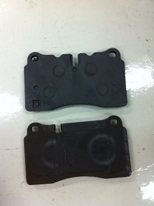 Brakes Pads - Which brand/compound is used on the Vantage V8 - Page 1 - Aston Martin - PistonHeads - The image displays two black plastic automobile bumpers against a white background. The bumpers appear to be in good condition with rounded edges. There are several holes of various sizes machined into each bumper, suggesting they are designed to allow for attachment or adjustment. There is no texture visible on the surface of the bumpers, indicating a smooth finish. The plastic appears of a good quality, likely durable for its intended use.