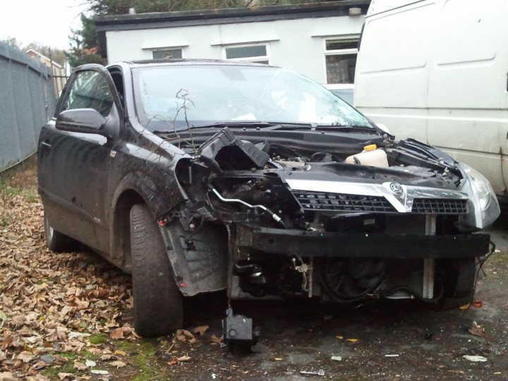 Show us your crash pics!! - Page 61 - General Gassing - PistonHeads - This image shows a crashed car with significant damage to its front. The vehicle appears to be a modern, small passenger car, featuring a crumpled hood and a torn bumper. The car is parked on a roadside, and its surroundings include fallen leaves, suggesting it might be autumn. There's another vehicle behind it, possibly a delivery truck, adding context that this could be a parking lot or a road where vehicles often stop. The photo does not show any people or moving traffic.