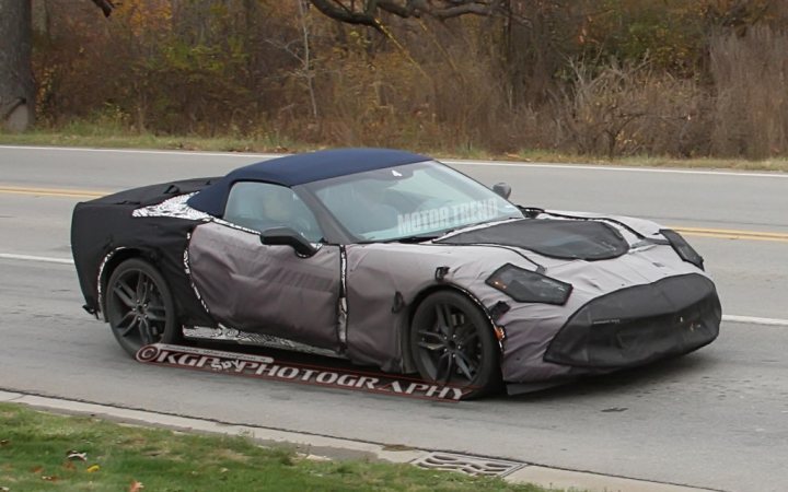 A car parked on the side of the road - Pistonheads - The image shows a vehicle driving on a street with trees and grass in the background. The vehicle appears to be a convertible sports car, with its top in a black, taut cover. The cover has white decals or logos across the hood. The photo has a watermark reading "KJO PHOTOGRAPHY," indicating the source of the image. The overall style of the image is a straightforward, unembellished photograph capturing the vehicle in motion against a natural backdrop.