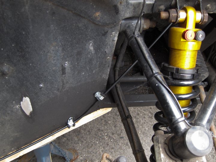 A bike parked on the side of a road - Pistonheads - The image shows a close-up of the underside of a vehicle, focusing on the suspension and engine components. The frame is cropped to emphasize the mechanical aspects, such as coil springs, shock absorbers, and other complex parts. There are exposed wires and components, suggesting that the vehicle might be under repair or being serviced. The highlight of the image is the vibrant yellow spring, which contrasts sharply with the darker colors of the rest of the vehicle's components.