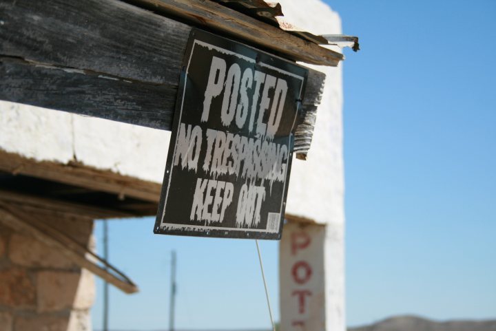 Exploring Urban Pistonheads Abandoned Stuff Machines - The image focuses on a wooden structure that appears to be in poor repair. Mounted on the front of the structure is a sign that definitively states, "POSTED NO TREADING KEEP OFF." Below the sign, there is another sign with additional text, but the text is not fully legible due to its position. The sky above the structure is clear and blue, contrasting with the aged and weathered look of the building. The style of the signs suggests a casual, hand-made quality, possibly serving as a humorous or ironic commentary on the crumbling structure.