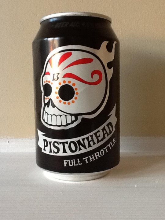 pistonheads drink - Page 1 - PH Shop - PistonHeads - The image displays a can of Pistonhead brand soda with a design resembling a skull, situated on a neutral, light-colored background which could be a wall at the can's lower part and a tabletop at the top part. The background is uniform and appears to be painted or wallpapered, providing a solid, nondescript backdrop for the can. The can stands on one of its sides, allowing a view of its design and text. It features a bold graphic of a skull with red flames and accentuated features. The number "13" is prominently displayed over the skull.