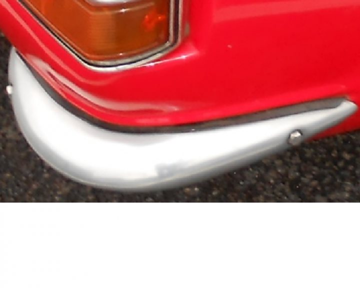 TVR Vixen Quarter Bumpers  - Page 1 - Classics - PistonHeads - The image shows a close-up of a red vehicle's front corner, focusing on the taillight. The taillight, with its shiny aluminum color, is partially visible and appears to be made of a reflective material. The angle of the photo suggests it's taken from the rear or the passenger side, capturing the example of why red tail lights are necessary for warning other drivers.