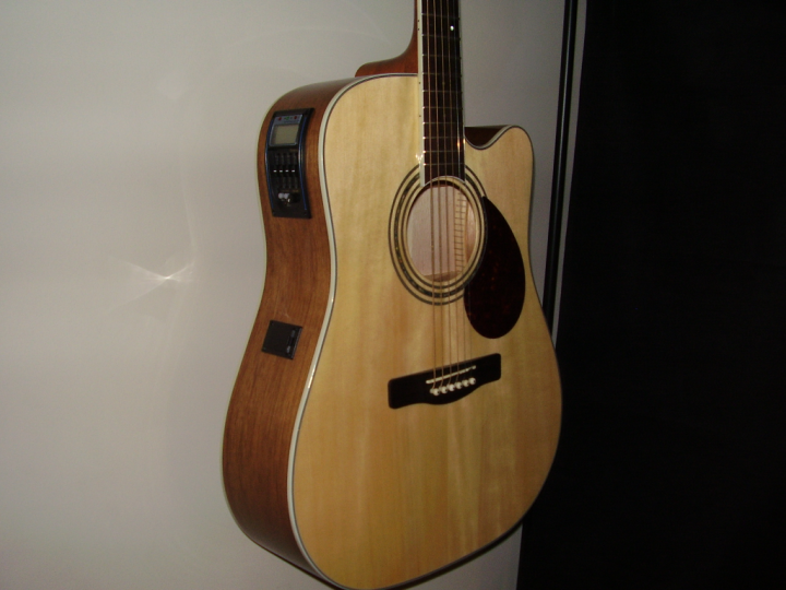 Pistonheads - The image captures a close-up view of a wooden guitar with a curved body and a cutaway. The guitar is mounted on a wall, mounted both vertically and horizontally. The guitar's wooden finish is highlighted by a built-in lighted accent on the body of the instrument, which also features a bridge and pickups. The guitar's neck has a set of tuning pegs, indicative of a fretted musical instrument. The overall image depicts a well-maintained and cherished musical instrument.