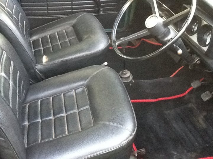 Newly Acquired Early Clubman - Page 1 - Classic Minis - PistonHeads - The image shows the inside floor of a car, revealing a stark contrast to the vehicle's exterior. It appears that the classic black and white Checkerboard floor covering has been removed, exposing the black carpet beneath. We can see the remnants of the old covering, as well as the protective floor mats underneath. The picture is taken from the perspective of the backseat, providing a clear view of the floor mat in the passenger seat and the carpet area surrounding the car's gear shift. The car's interior seems well-maintained, but the absence of the original Checkerboard floor covering gives it a vacant look.