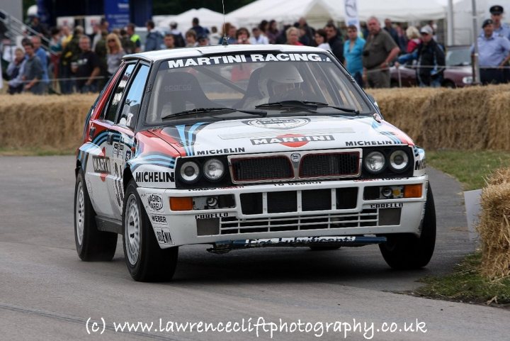 North Body Pistonheads Cheshire Staffs South - The image captures a scene on a race track. A car painted in hues of white, red, and black is in the center of the frame, adorned with multiple logos including Michelin and Martini. The details suggest it is a rally or race car. In the background, spectators can be seen, providing a sense of the event's atmosphere and scale. The track itself is well-maintained, indicative of a professional racing event.