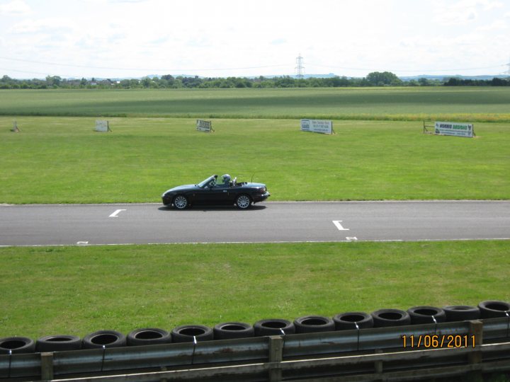 Pistonheads - The image shows a small car driving down a racetrack. There are barriers, possibly consisting of stacked tires, lining the sides of the track, suggesting a course intended to minimize the risk of accidents. The car appears to be in motion and is the primary subject of the photo. The term "bending rule is enough legal" suggests a context of discussion about the car's actions.