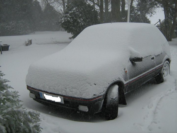 Pistonheads Gti Snow Poor - The image shows a car covered with a thick layer of snow. It is taken from a side angle that captures the roof and three-quarter view of the side of the car. There is a vehicle's license plate visible, but for privacy reasons, it should not be mentioned. The car is stationary on a snow-covered surface, and the surrounding environment is also coated with snow, giving the impression of a cold, wintery day. The sky appears to be overcast or cloudy, which indicates possible continuing snowfall. The scene suggests a parking area, and the dense snow could make accessing or moving the car quite challenging.