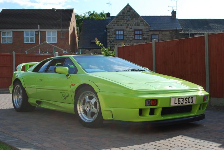 Pistonheads - The image displays a lime green sports car parked on a brick-paved driveway. The vehicle's license plate is identifiable as L63 SO0. It is a classic two-door model, likely a version of a Ferrari or a similar prestige make. The background features a residential street with houses and a fence. The sky is partly cloudy, suggesting soft, diffused lighting. The car has the distinguishing feature of a trident logo, which is characteristic of the Ferrari marque.