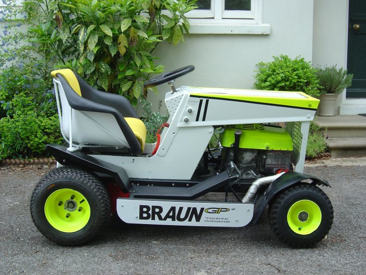 Diary Racing Lawnmower Midlife Pistonheads Crisis - The image features a powerful-looking lawn mower with a lime green and white paint scheme. It's equipped with oversized tires for improved maneuverability on grass. The tall grass and plants in the background suggest that the mower could be in use. The numbers "GPX" and "X" indicate that this is a product of the Grasshopper Company, known for their lawn mower designs.