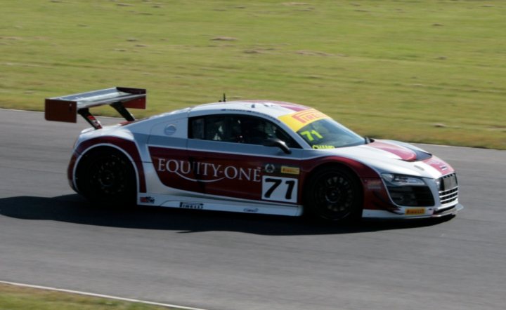 A red and white truck parked on the side of a road - Pistonheads - This image features a powerful sports car in motion. The car is boldly colored in a mix of red, white, and blue, with a large spoiler wing affixed to its rear deck, aiding aerodynamics during high-speed runs. The vehicle bears the number '71' on its side and front bumper, supporting a racing bib, indicating that it might be partaking in a motorsport competition, such as the GT or touring car category. The setting appears to be a road racing track or a similar venue designed for high-performance vehicles. The car is moving at high speed, as the presence of grass next to the track and the motion blur on the wheels and the background suggest.