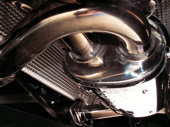 Pistonheads - The image shows a close-up view of a motorcycle's engine or frame. The metallic surface of the bike reflects some light, indicating that the surface is likely polished or well-maintained. The shape suggests a part of the bike's chassis or exhaust system. There are no visible texts or branding in the image. The style of the image is a real-world photograph with artistic focus, emphasizing the bike's design.